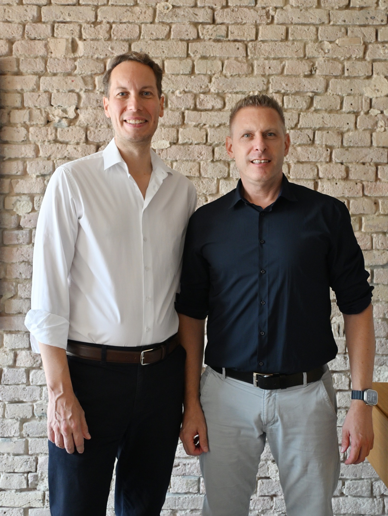 Markus Grube (links) und Bernd Mrohs (rechts), die Gründer von exarail, vor einer Backsteinwand